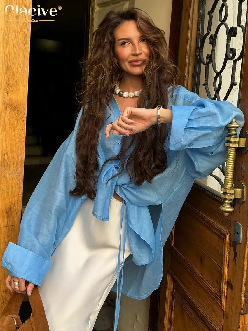 Clacive blue loose blouse with long sleeves and front tie, paired with a white skirt