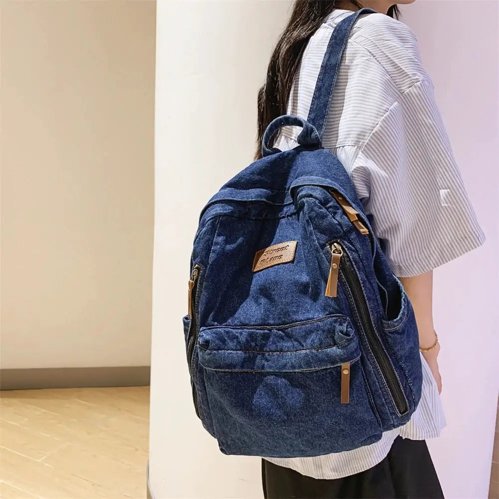 Denim backpack by Simples Market with multiple pockets, large capacity, and tan zipper pulls