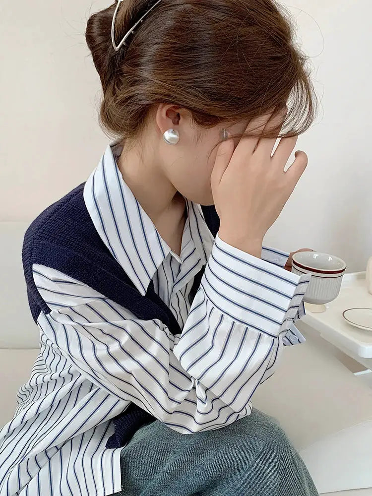Earrings with silver-tone pearl studs worn by a woman