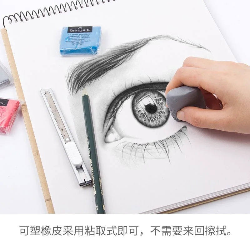 Faber-Castell kneaded eraser in hand erases details on eye sketch; blue and pink erasers, ruler and craft knife nearby.