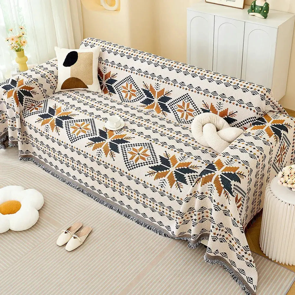 Sofa throw blanket by Simples Market in cream with navy and tan geometric pattern and fringed edges.
