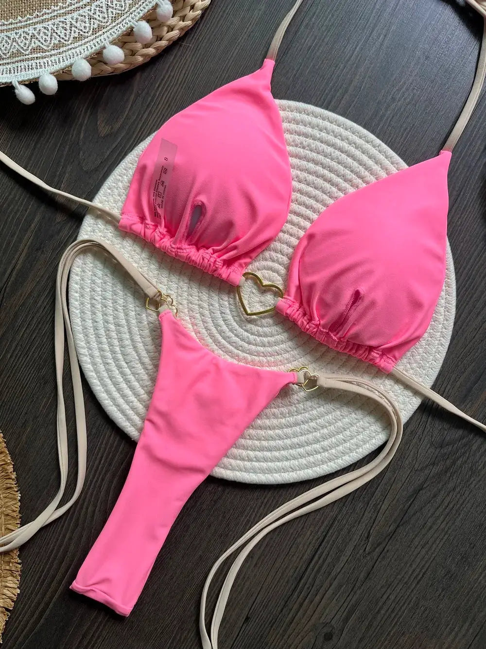 RUOTONSEPT pink two-piece halter bikini set with triangle top and thong bottom on a round woven mat.