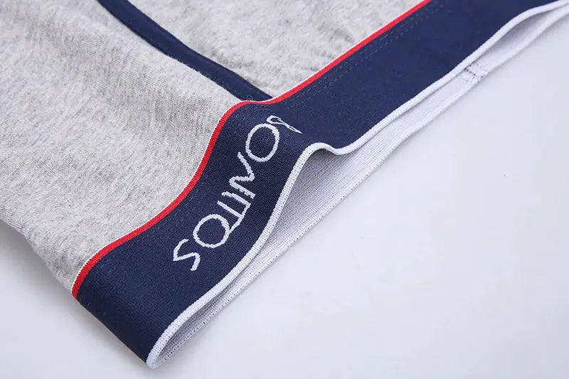 Men's boxer shorts by Simples Market, gray cotton with navy waistband and red trim.