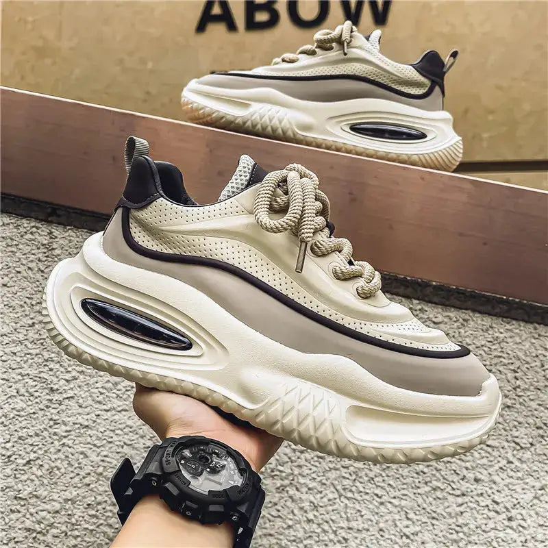 Two beige men's casual sports shoes with thick chunky soles, black piping, and rope laces