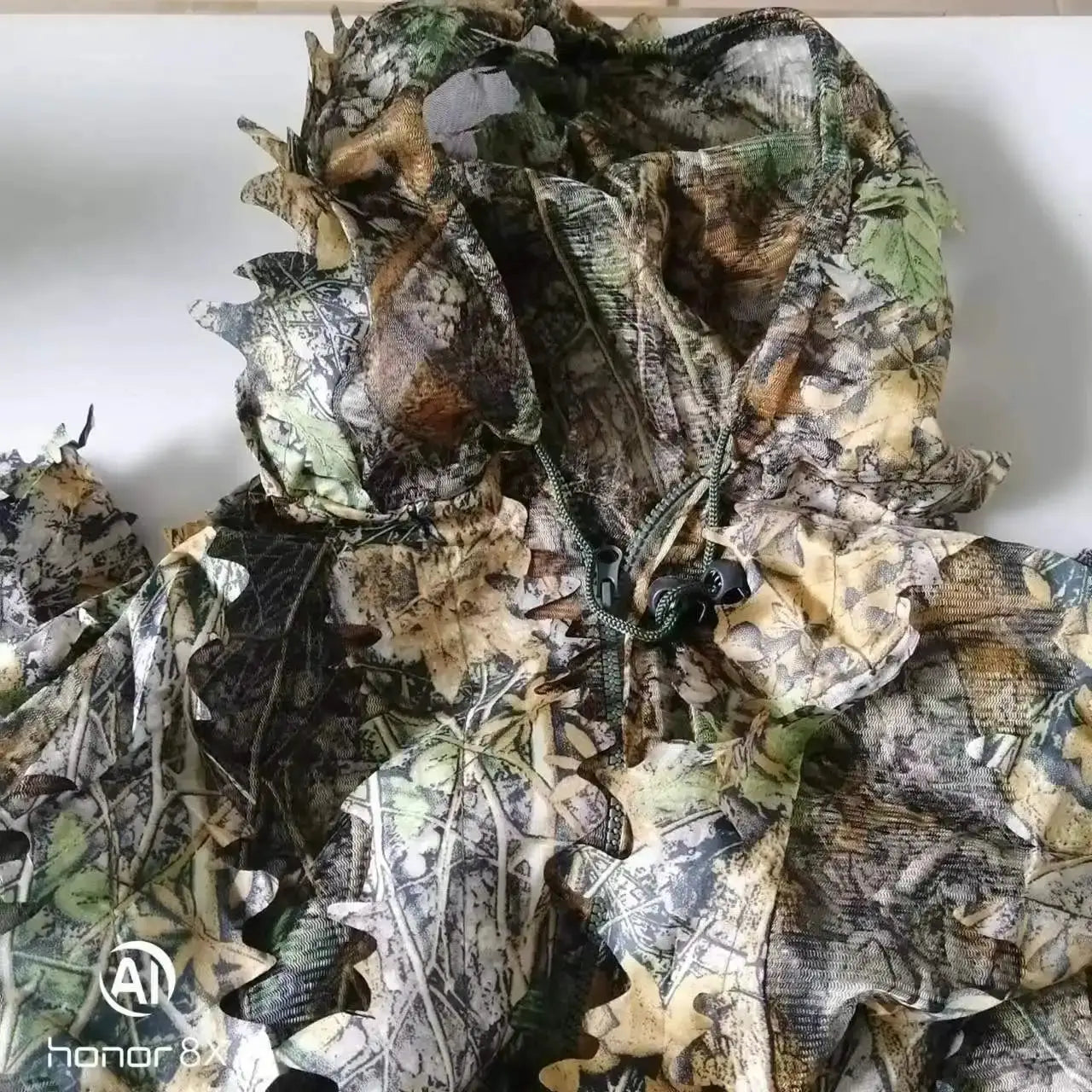 Ghillie suit with hood in woodland camouflage leaves pattern; jacket and pants set.