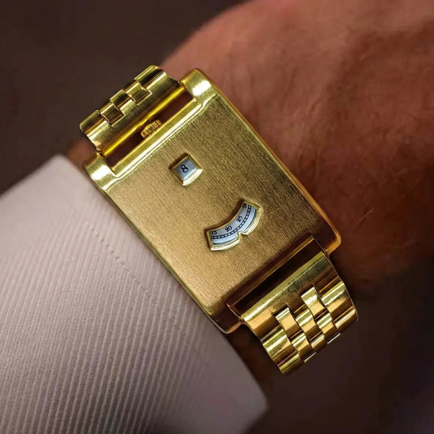 Gold square men's tank watch with a link bracelet and date window.