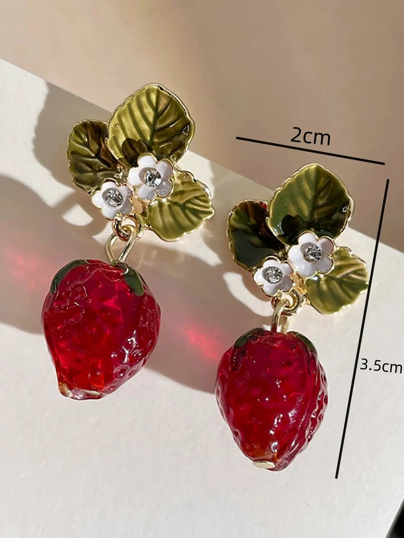 Earrings: green leaf floral tops with white flower accents and red strawberry drop beads (pair)