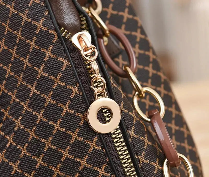 Women's bucket handbag with flip-check print in brown and tan, gold hardware and crossbody strap.
