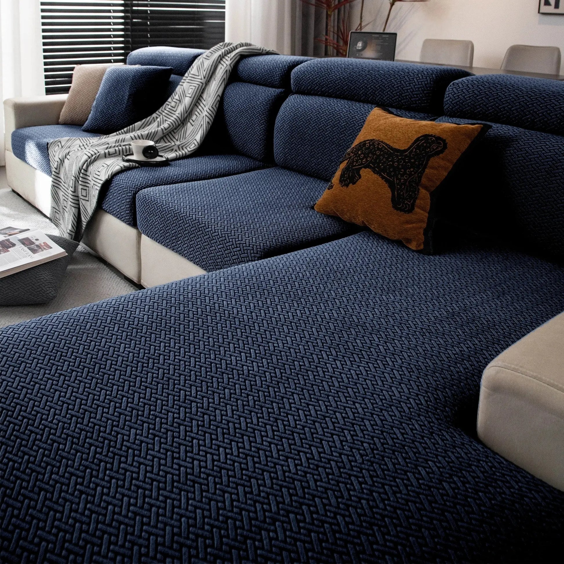 Stretchy polar fleece sofa cover in blue on a patterned blue sofa; elastic universal fit