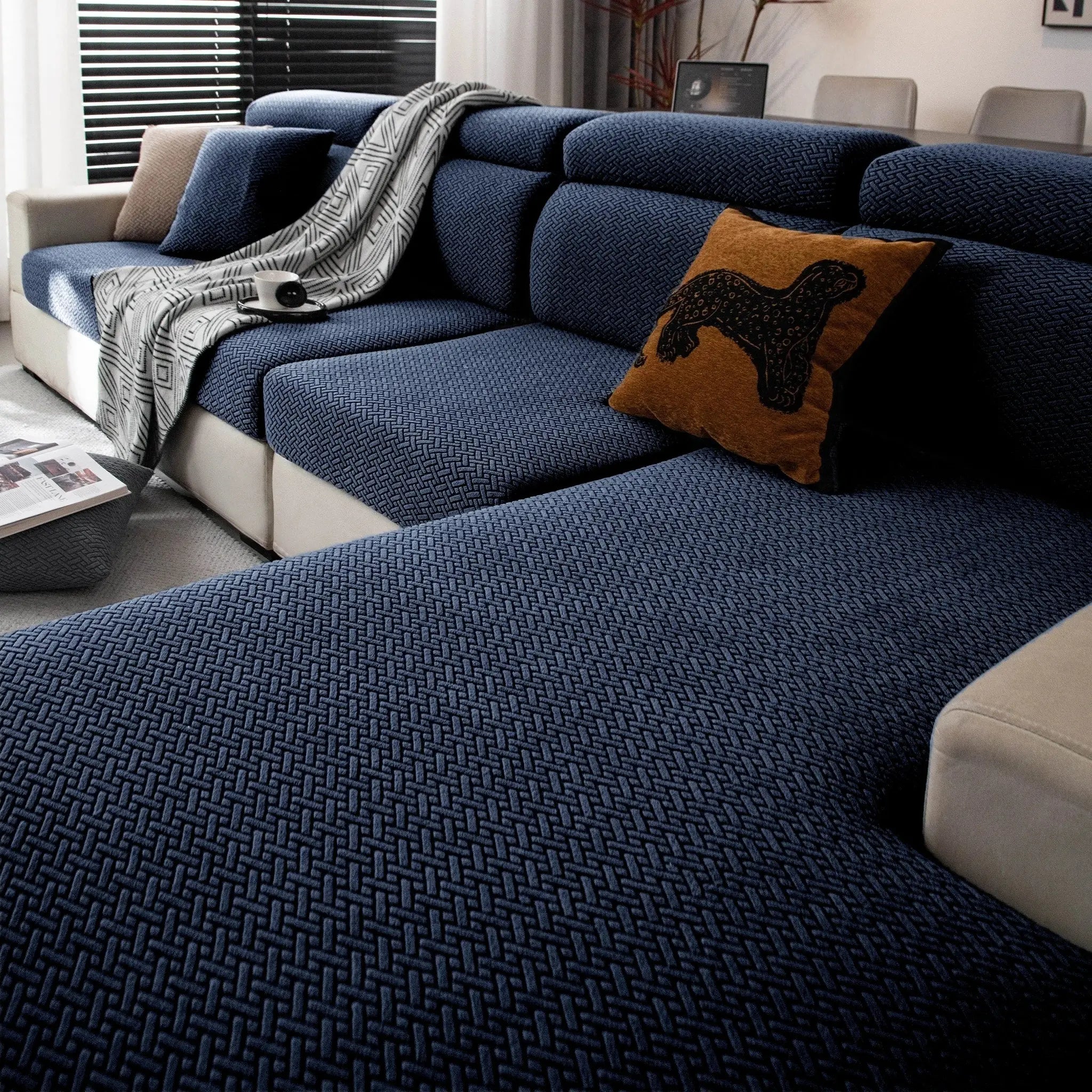 Stretchy polar fleece sofa cover in blue on a patterned blue sofa; elastic universal fit