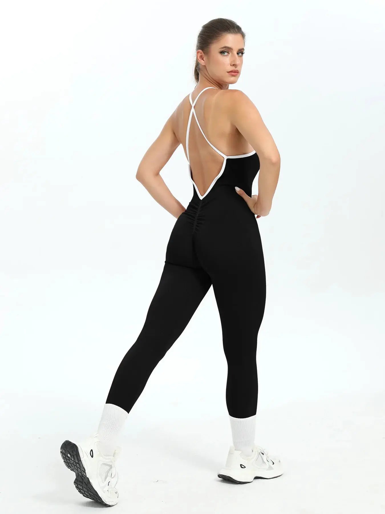 Womens seamless ribbed jumpsuit with black body, white trim and crisscross back straps