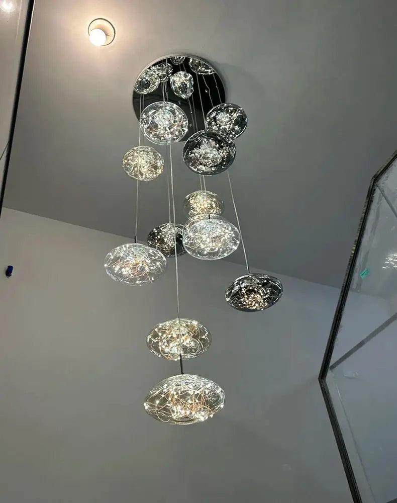 Glass orb pendant lights cluster for dining room; clear glass spheres with LED filaments.
