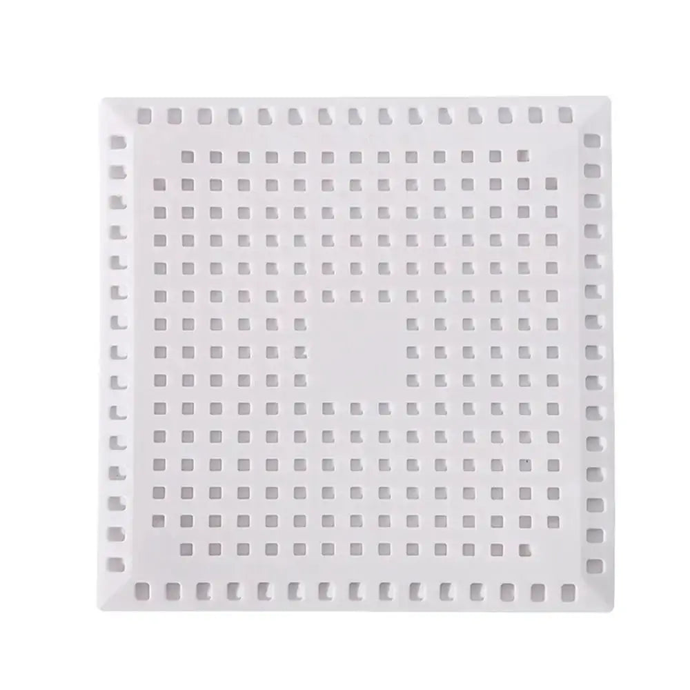Square white kitchen sink drain strainer with perforated grid pattern and anti-clogging design
