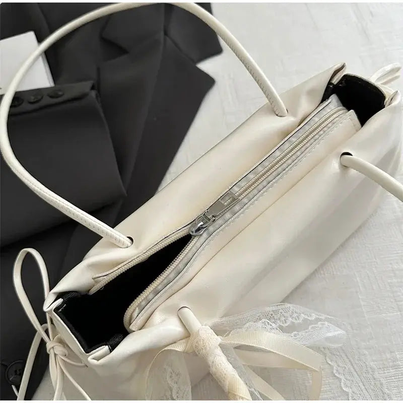 Shoulder bag in cream PU with lace bow detail and top zipper