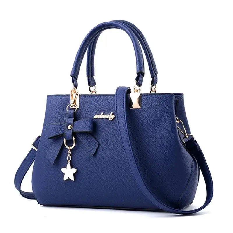 Simples Market blue handbag with bow and flower charm, twin top handles, crossbody strap