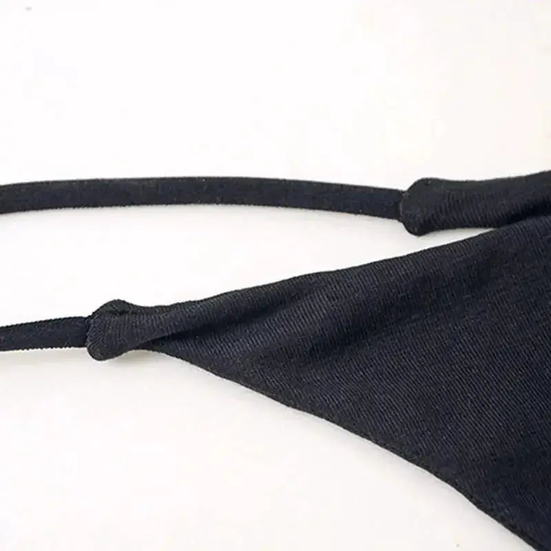 Women's black thong underwear with thin side straps, close-up view of smooth fabric