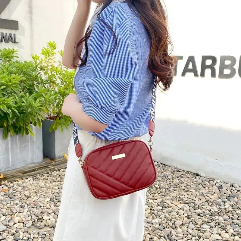 Shoulder bag: red quilted PU with diagonal stitching and metal plaque, crossbody strap