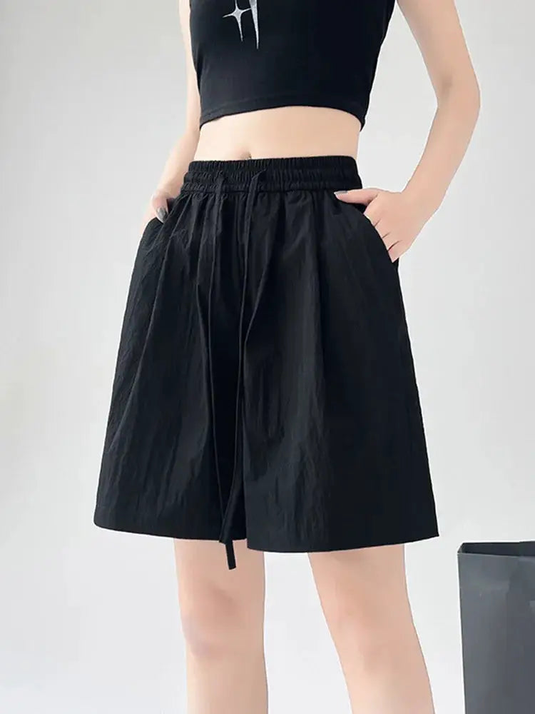 Women's black casual shorts with elastic high waist, two pockets, loose knee-length