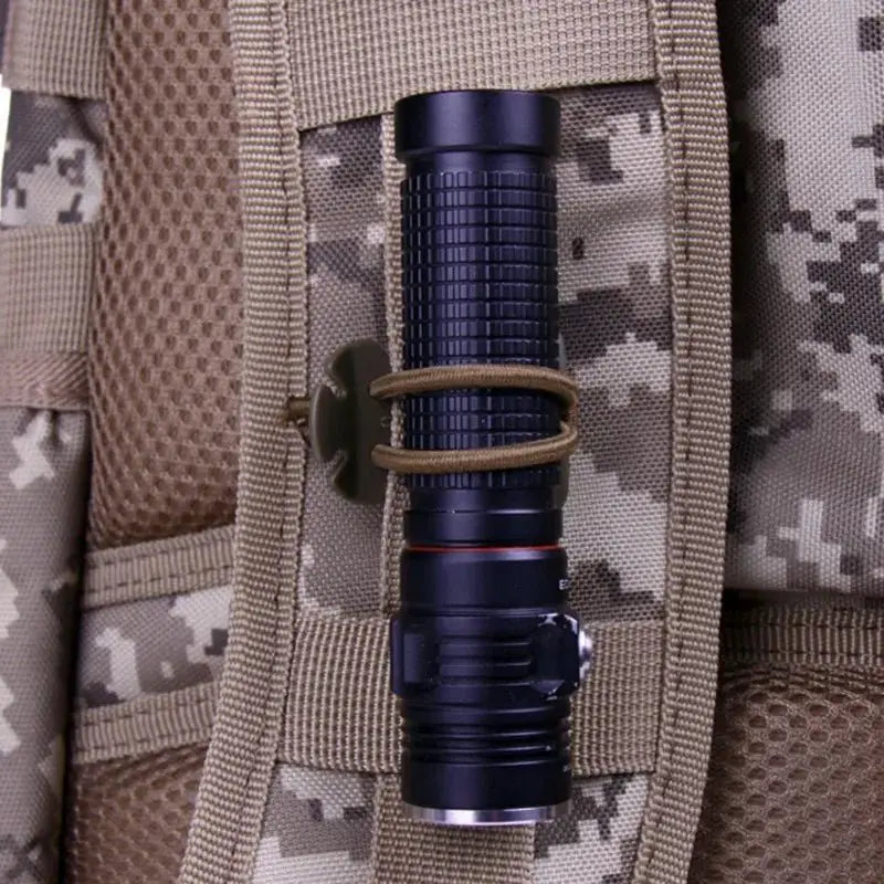 tactical backpack buckle carabiner holding a flashlight on a camouflaged tactical backpack