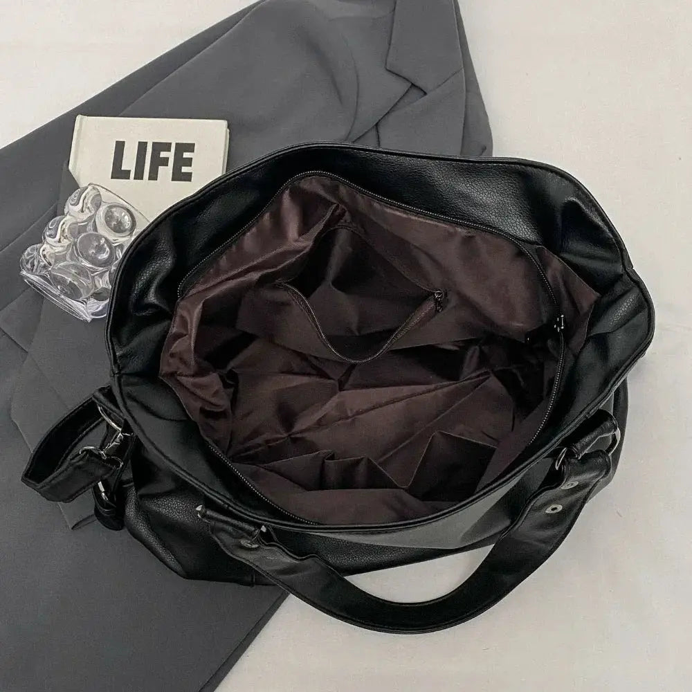 Soft interior black PU leather shoulder bag by Simples Market with brown lining and roomy main compartment.