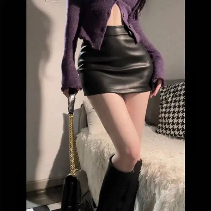 Leather matte mini skirt, black PU, high-waisted; styled with knee-high boots and a purple cardigan