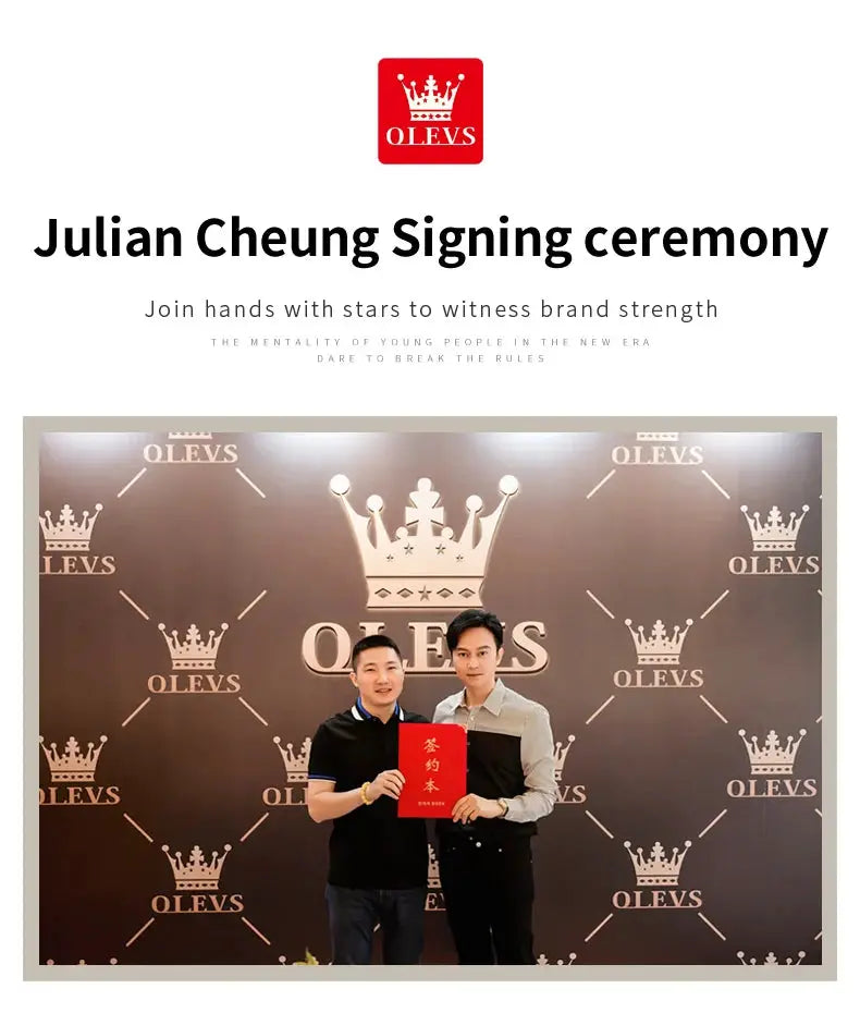 OLEVS signing ceremony backdrop with crown logos; two men pose in front of a branded wall, holding a red booklet.