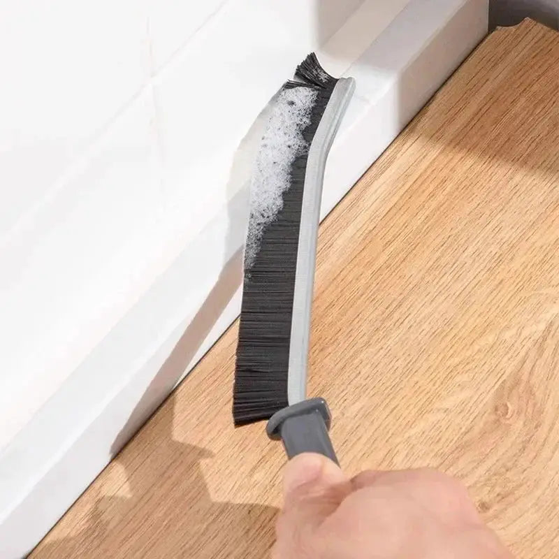 Grout cleaning brush with hard black bristles and gray plastic handle for tile joints