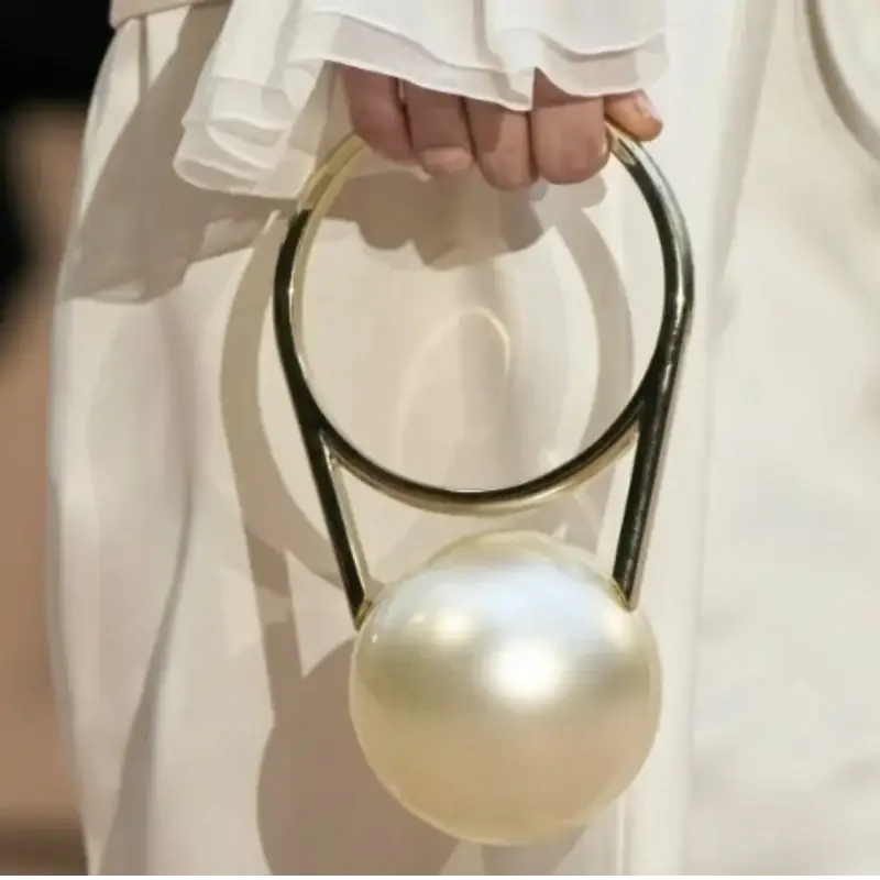 Luxury designer evening clutch with pearl ball handle and circular gold-tone ring, acrylic bag by Simples Market