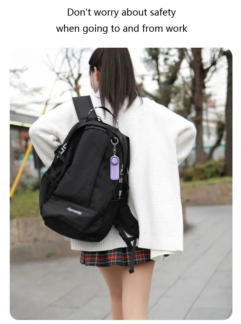 130dB Protect Alert personal defense siren attached to a black backpack with a purple unit