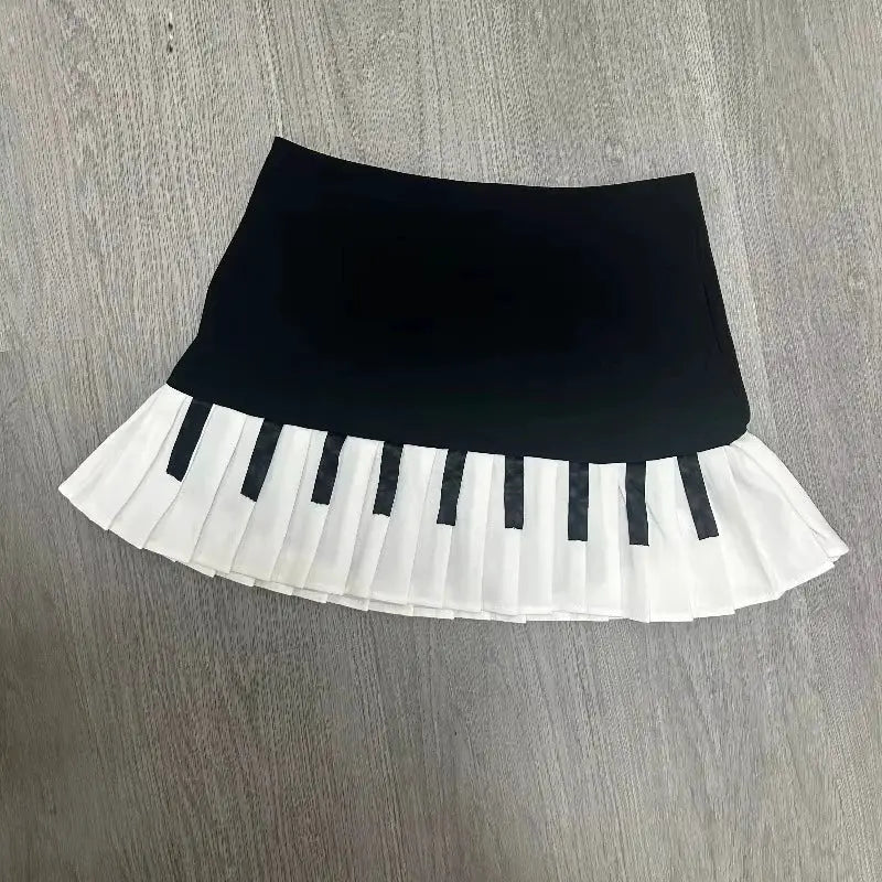 Black spliced mini skirt with white pleated piano-key hem.