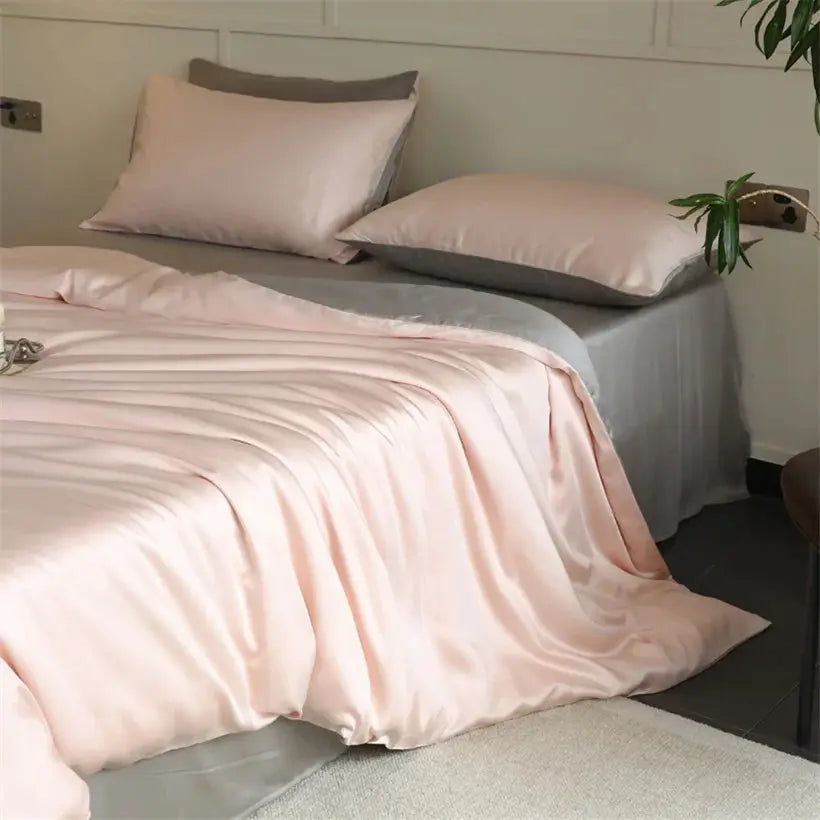 Mulberry Silk bedding set by Simples Market in pink silk duvet cover and pillowcases on a bed with gray sheets