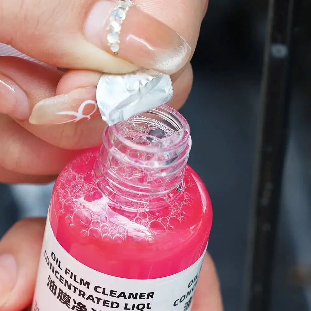 Oil film cleaner bottle for car glass with pink liquid and bubbles