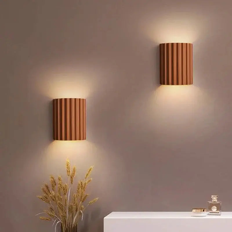 Nordic modern resin wall lamps, two ribbed brown cylindrical fixtures casting warm light on a beige wall
