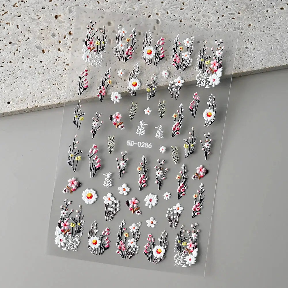 Nail charm sticker sheet by Simples Market; dozens of 5D embossed floral decals in white, pink and yellow for summer manicure