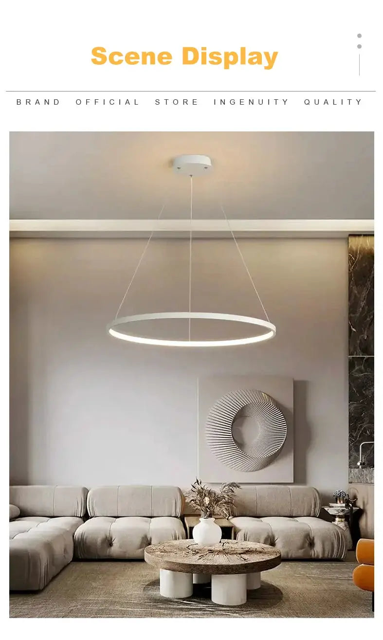Modern round white LED pendant light hanging over beige living room seating.