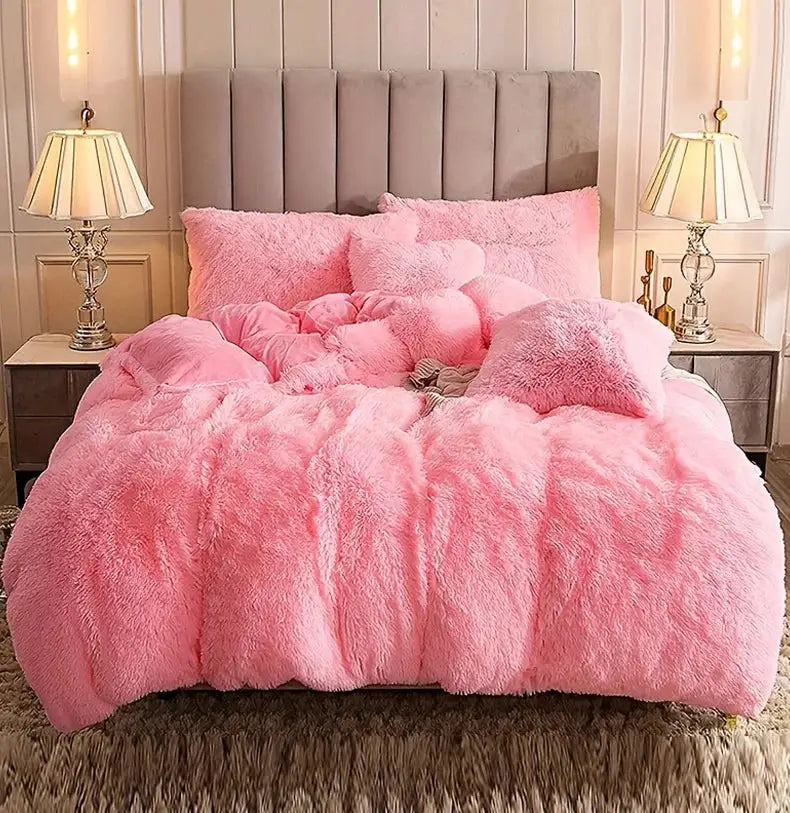 3-Piece plush pink duvet cover set with matching fluffy pillows on a bed
