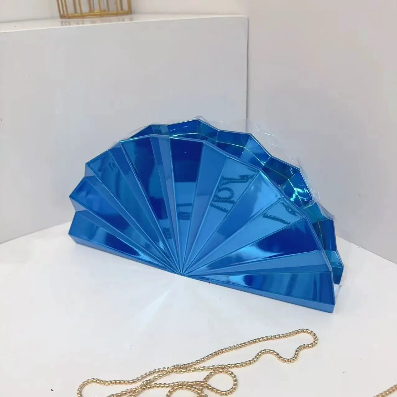 Moon-shaped blue acrylic purse; box clutch with gold chain strap