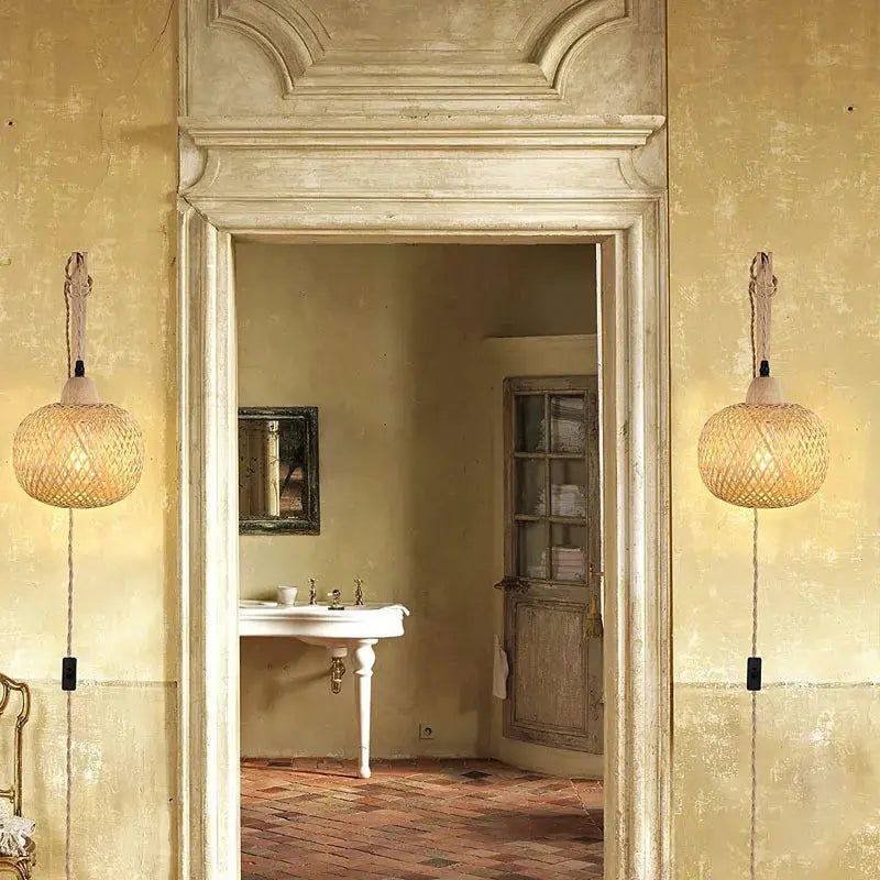 Bamboo lantern wall lamps (pair) with hand-woven natural rattan shades, wall-mounted in a rustic room.