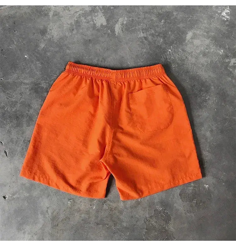 Men's orange swim shorts with elastic waistband and back pocket.
