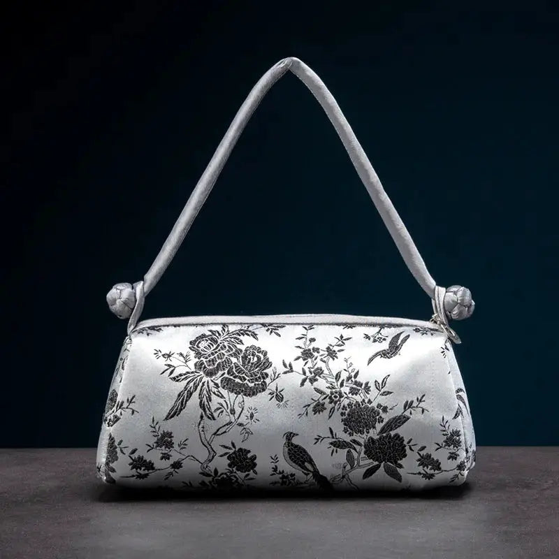 Embroidered satin shoulder bag by Simples Market; silver-white with black floral embroidery, top-handle.