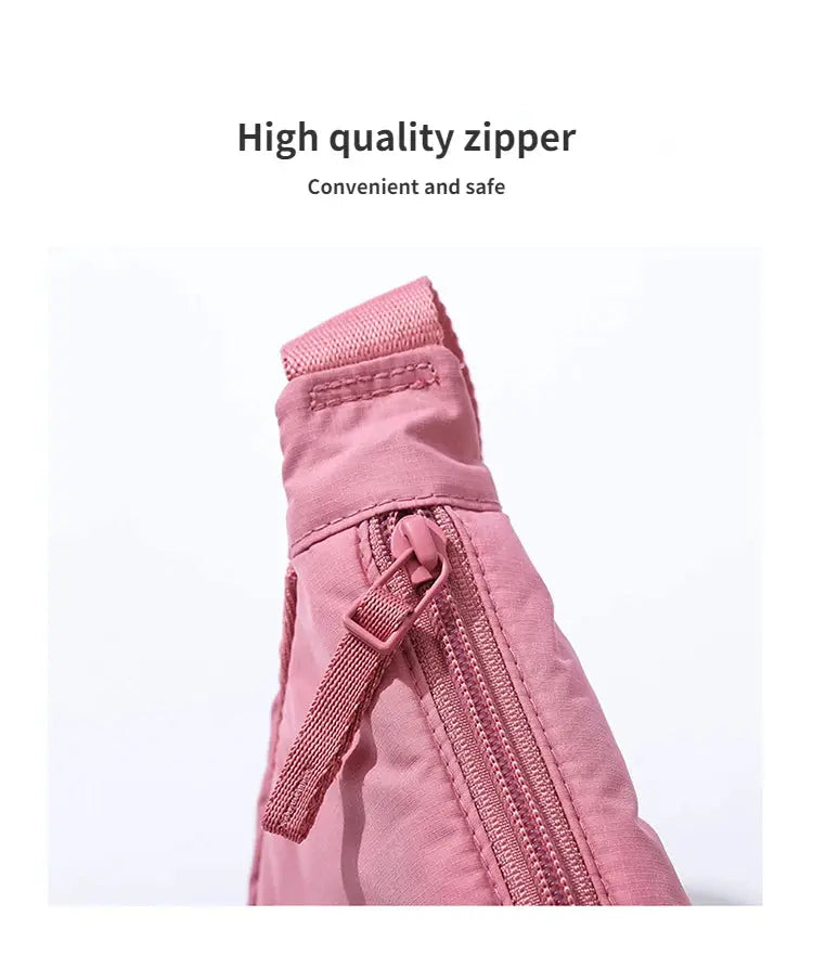 Pink nylon crossbody bag by Simples Market with zippered pocket and adjustable strap.