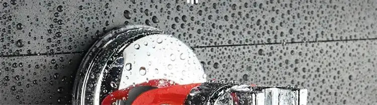 Chrome shower head bracket with suction cup base on wet tiled wall