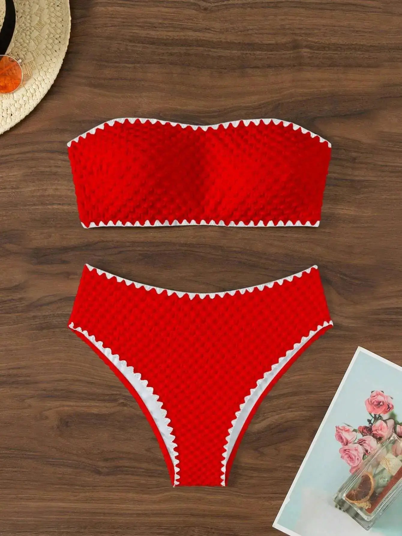 Red textured two-piece strapless bikini with white zigzag trim, bandeau top and matching high-cut bottoms.