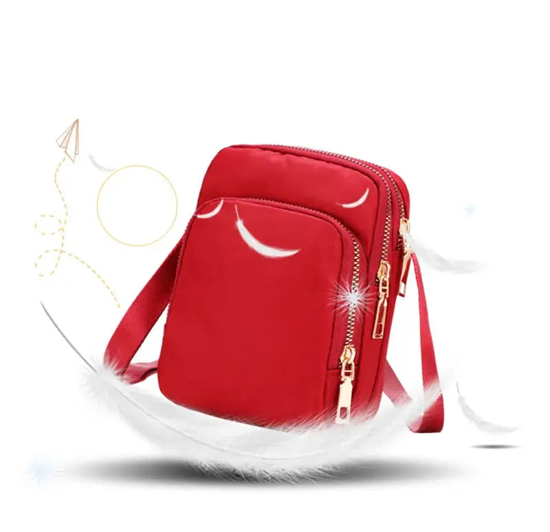 Red waterproof women's crossbody bag with multiple zip pockets and adjustable strap