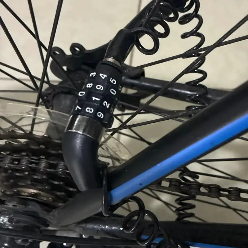 4-digit combination bike lock by Simples Market with a black cable secured to the bicycle frame