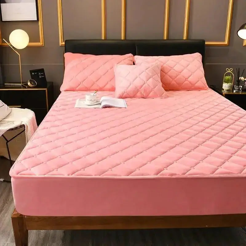 Pink crystal velvet plush quilted fitted mattress cover on bed with two matching pillows