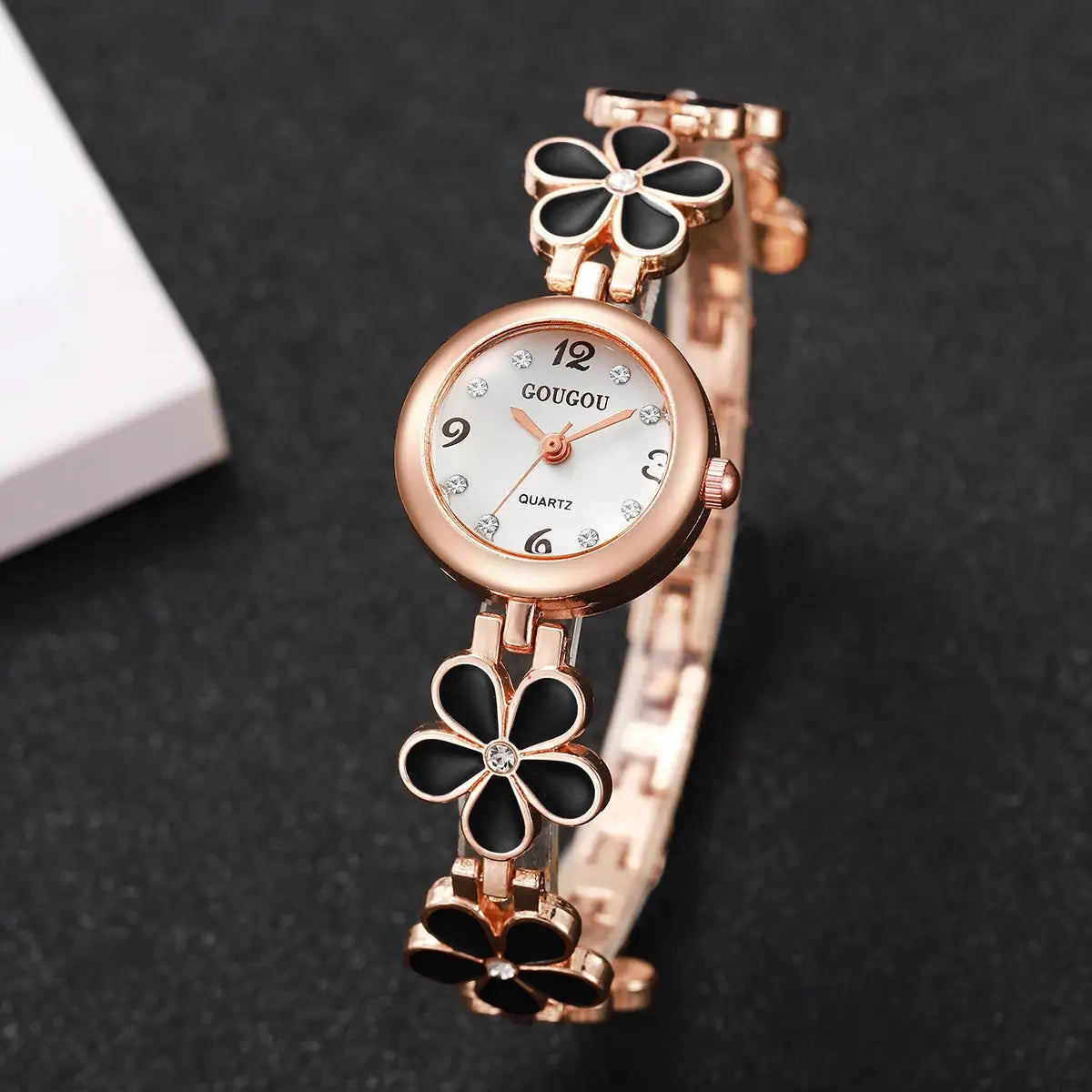 Rose-gold women's bracelet watch with black enamel flower links and crystal accents on a white dial GOUGOU