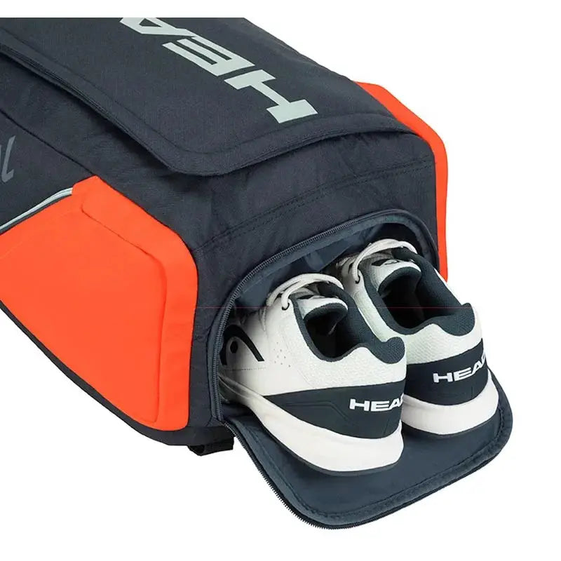 HEAD Original Radical Tennis Backpack navy with orange panels; white HEAD shoes tucked into the open compartment
