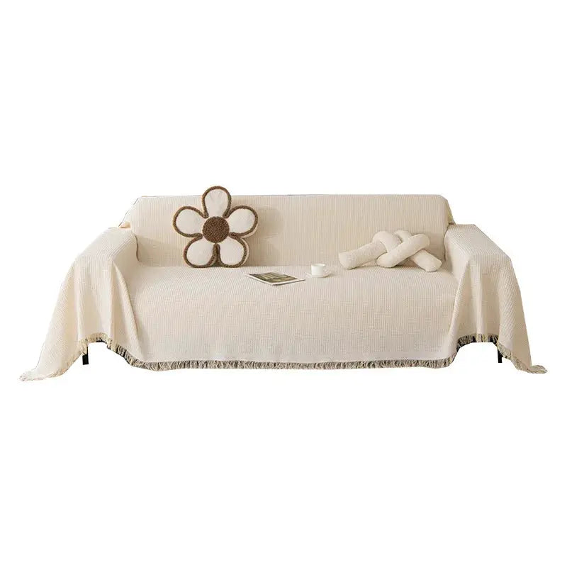 Sofa towel throw in cream wind cotton yarn with fringe, on sofa with flower pillow