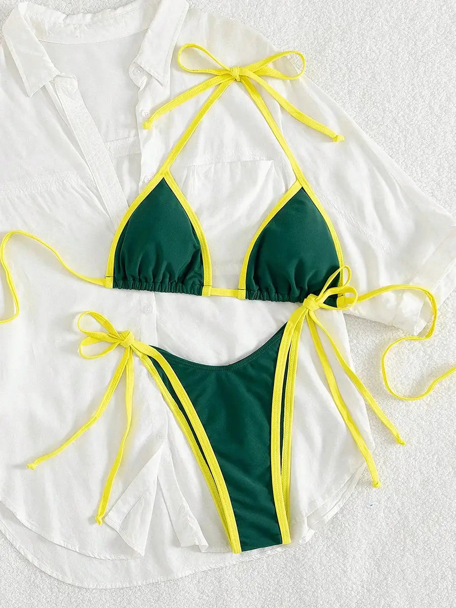 Simples Market two-piece green bikini swimsuit with yellow trim and ties laid over a white shirt